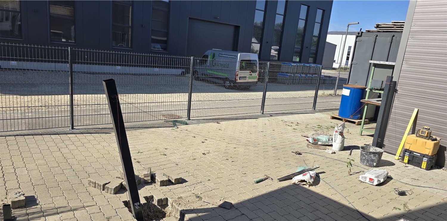 Pfosten werden bei der Montage im Pflaster gesetzt