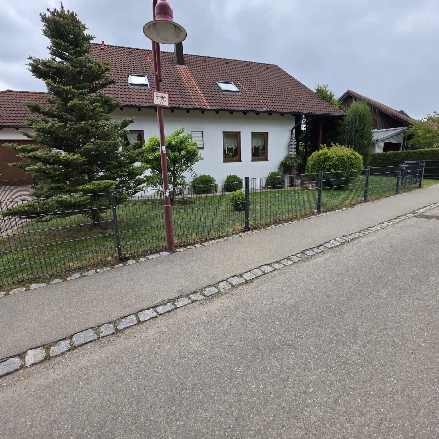 Gerade montierter Doppelstabmattenzaun entlang eines Grundstücks
